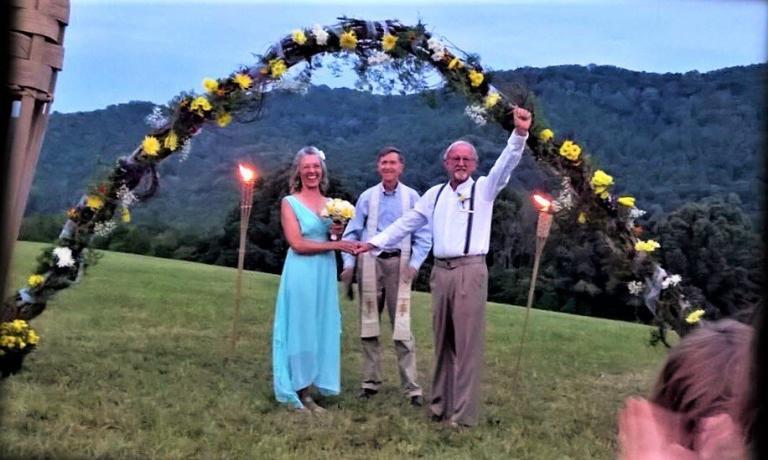 bride and groom celebrate under flowered arch